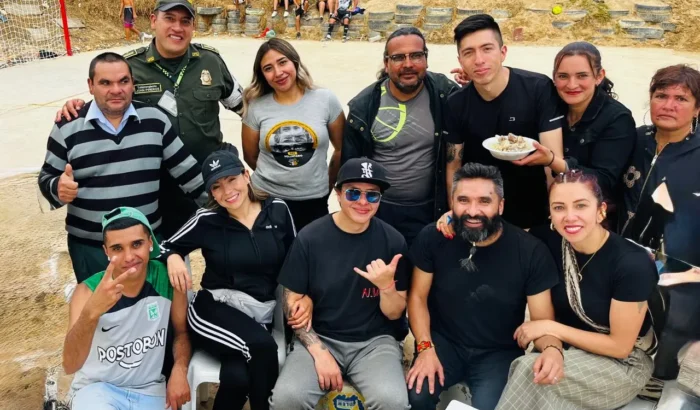 Grupo de personas sonriendo juntas en un espacio exterior durante una actividad comunitaria